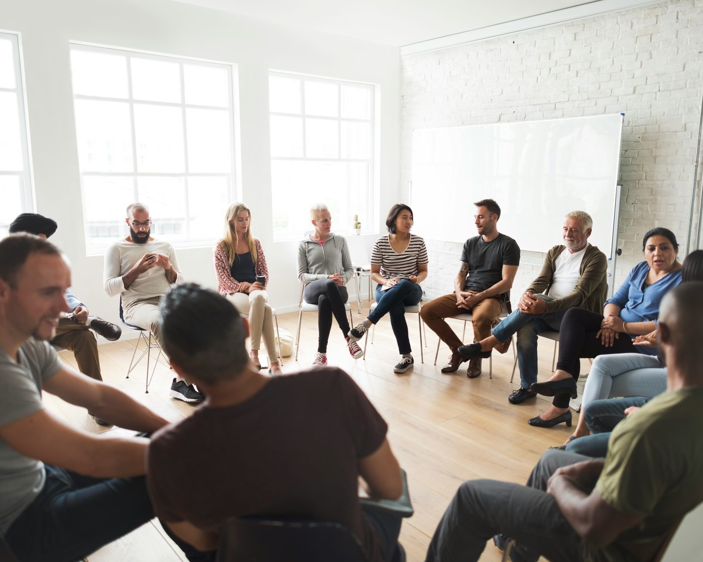 People in a SMART Recovery meeting, seated in a circle in a bright room